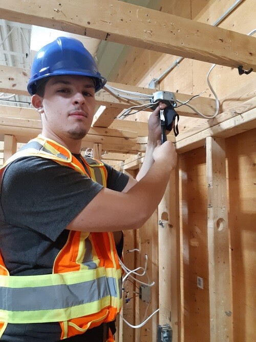 Picture of a student in a safety vest hanging wires